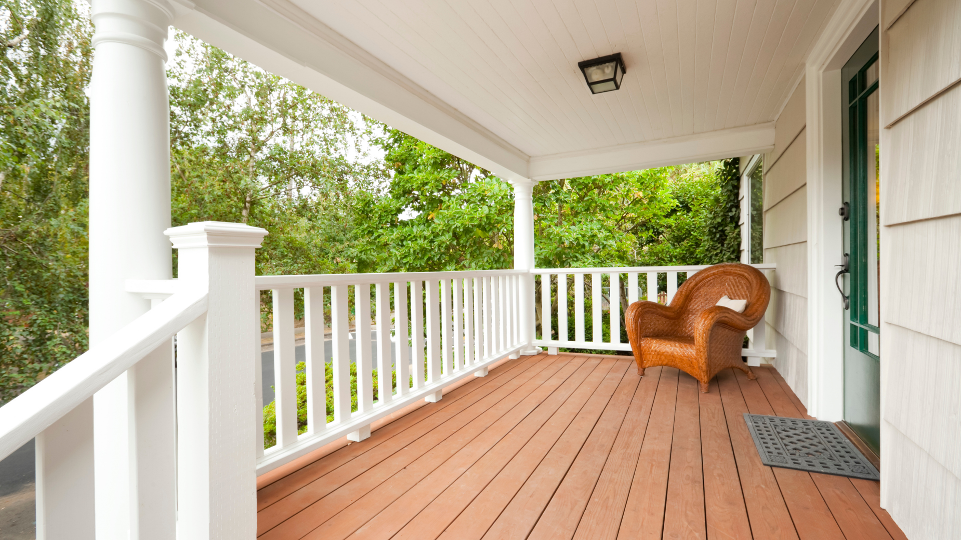A porch with a chair and a white railing