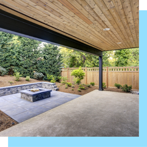 A patio with a fire pit and a wooden fence.