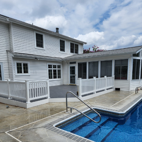A large white house with a swimming pool in front of it