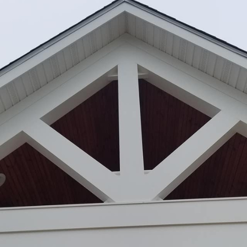 A white building with a triangle shaped roof