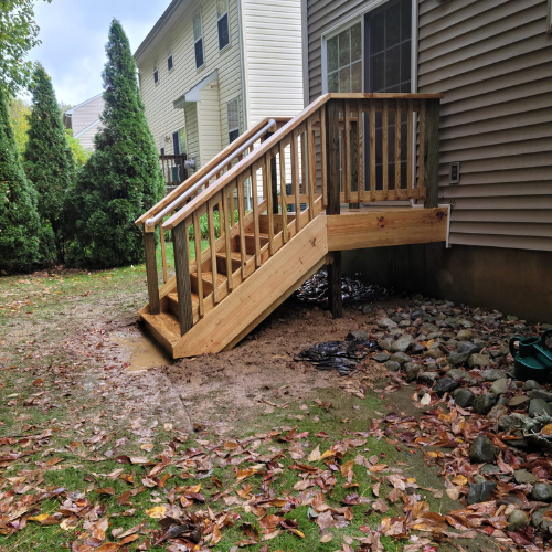 A wooden deck with stairs in front of a house