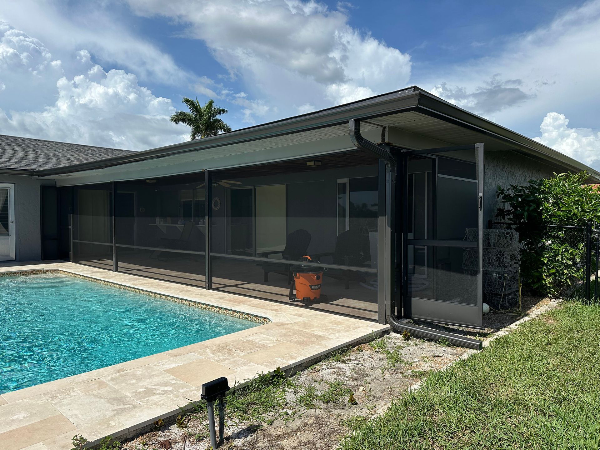 A house with a screened in porch and a swimming pool.