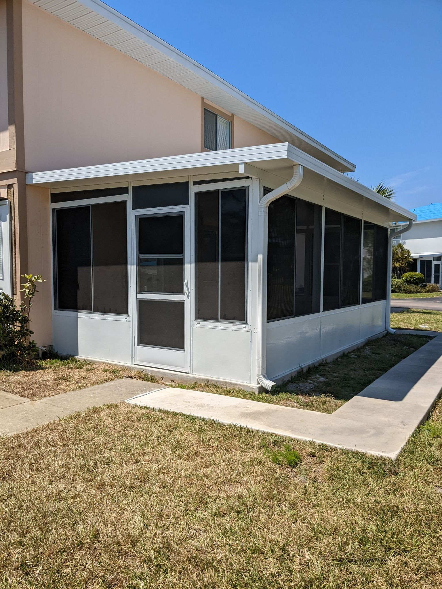 A house with a screened in porch on the side of it.