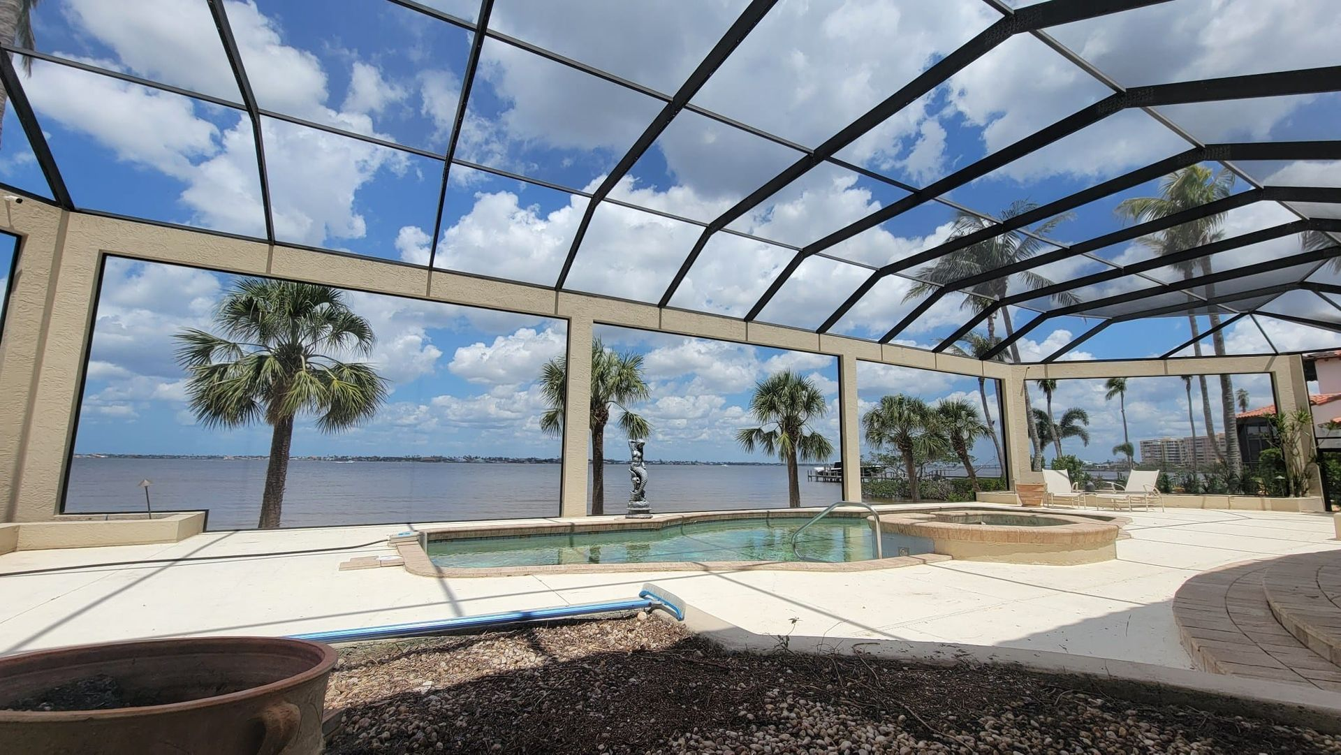 A swimming pool with a view of the ocean and palm trees