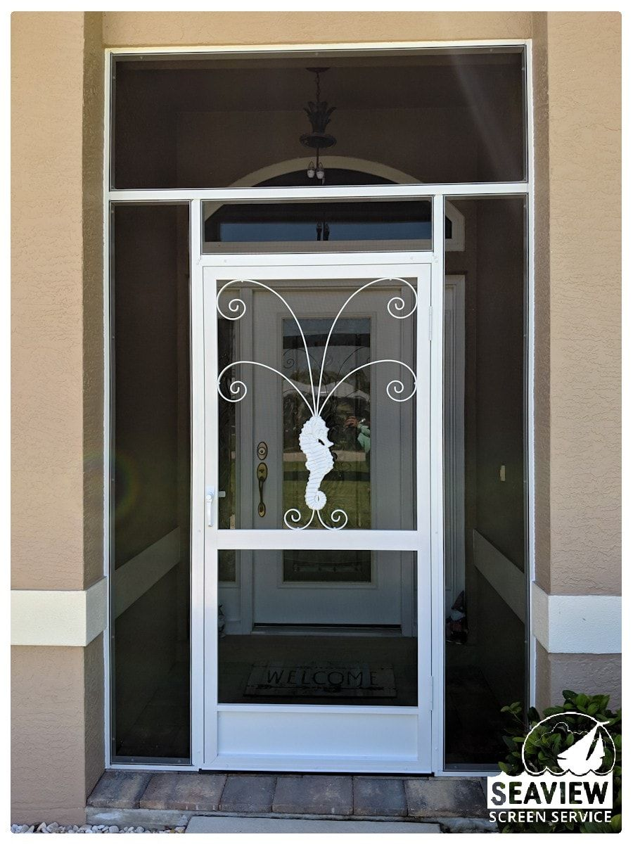 A white screen door with a seahorse on it
