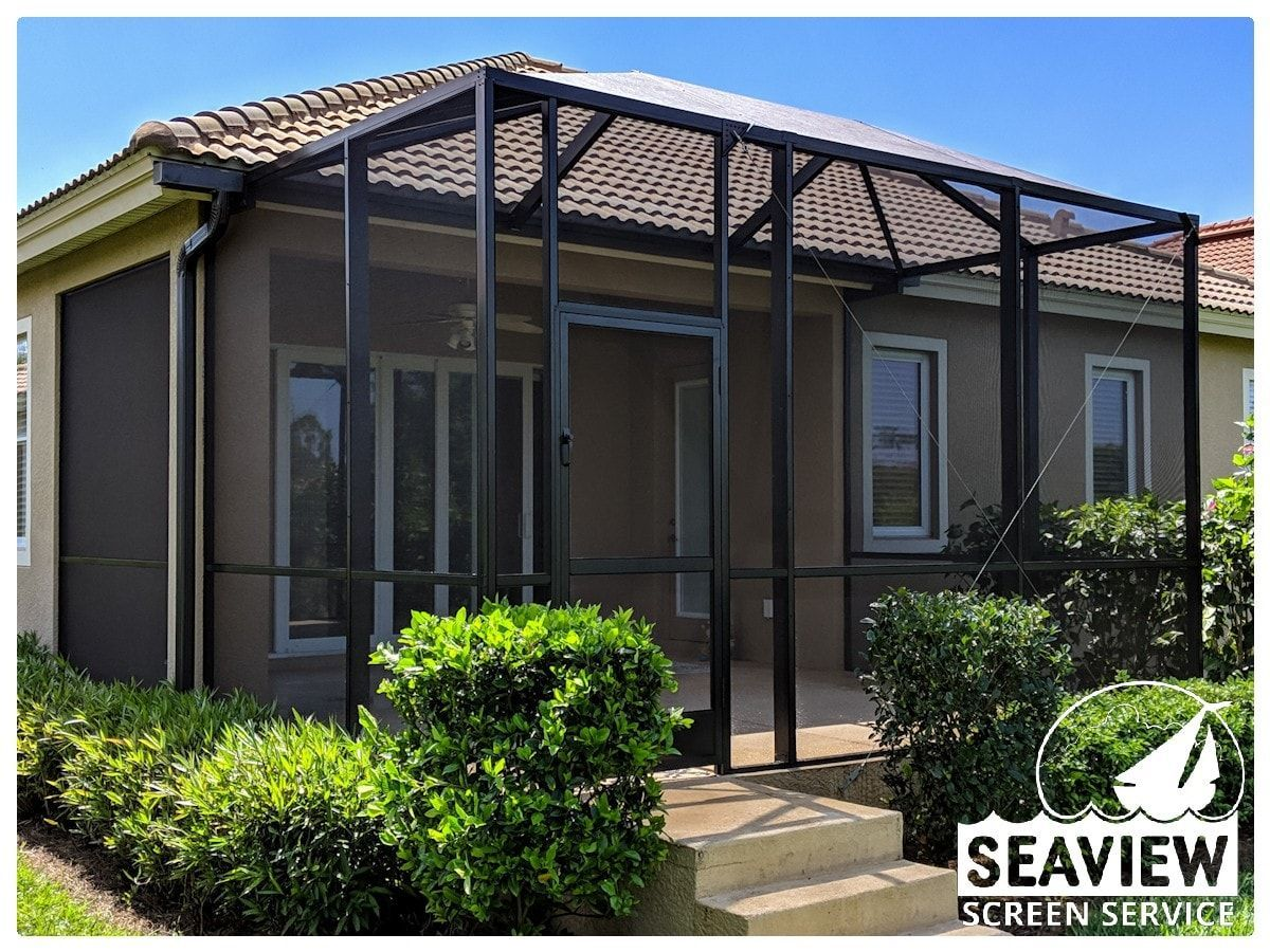 A screened in porch on the side of a house.