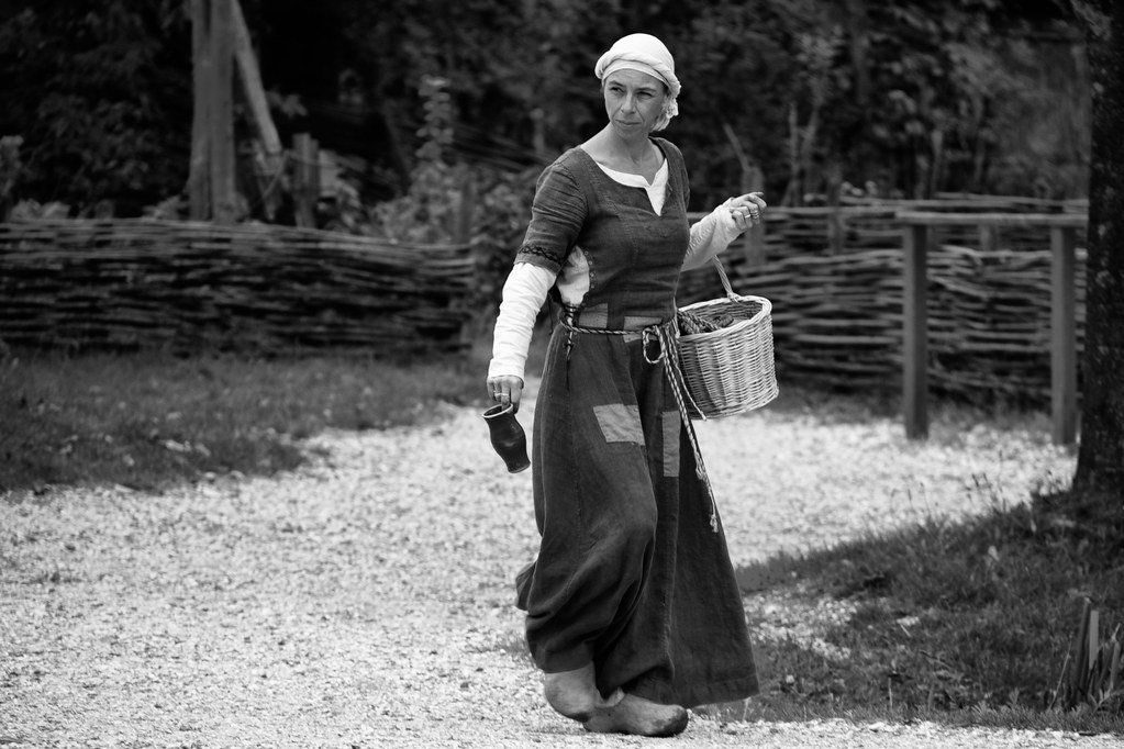 Vrouw in middeleeuwse kleding met mand en kruik door Hans Splinter