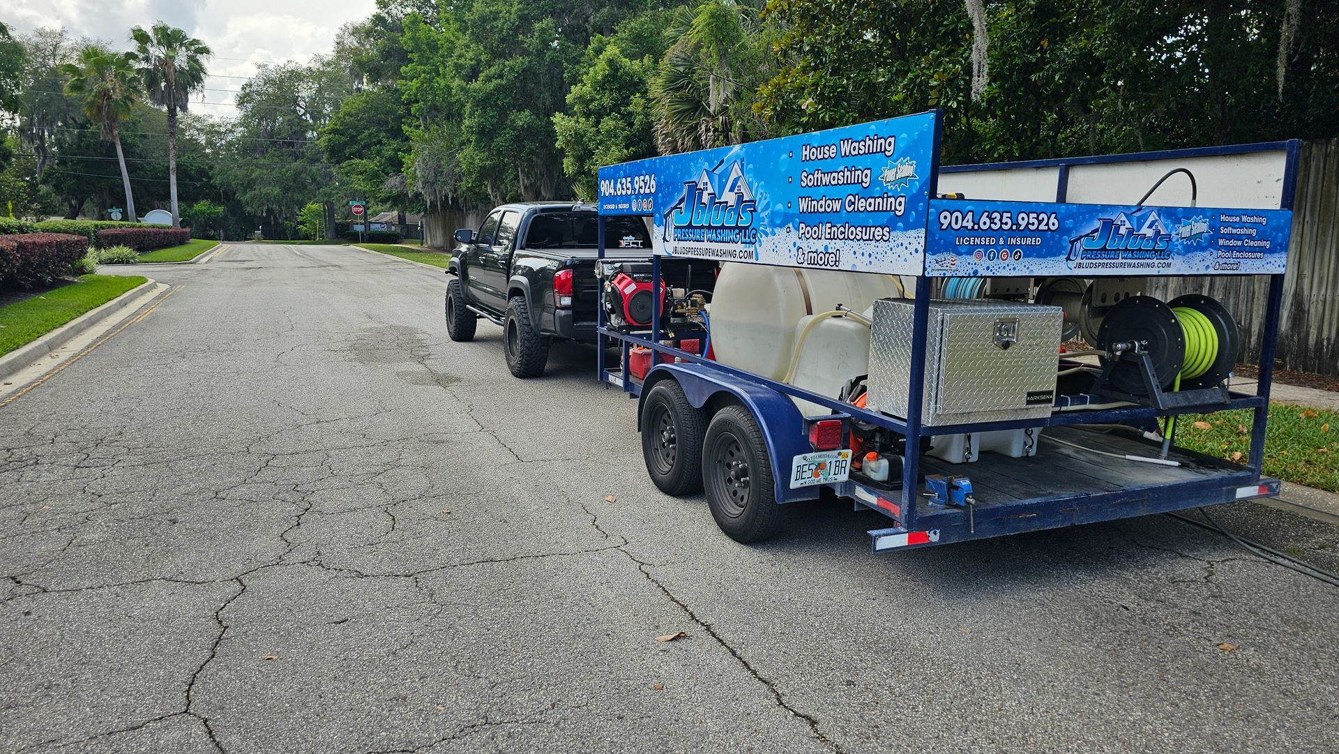 A truck and trailer are parked on the side of the road.