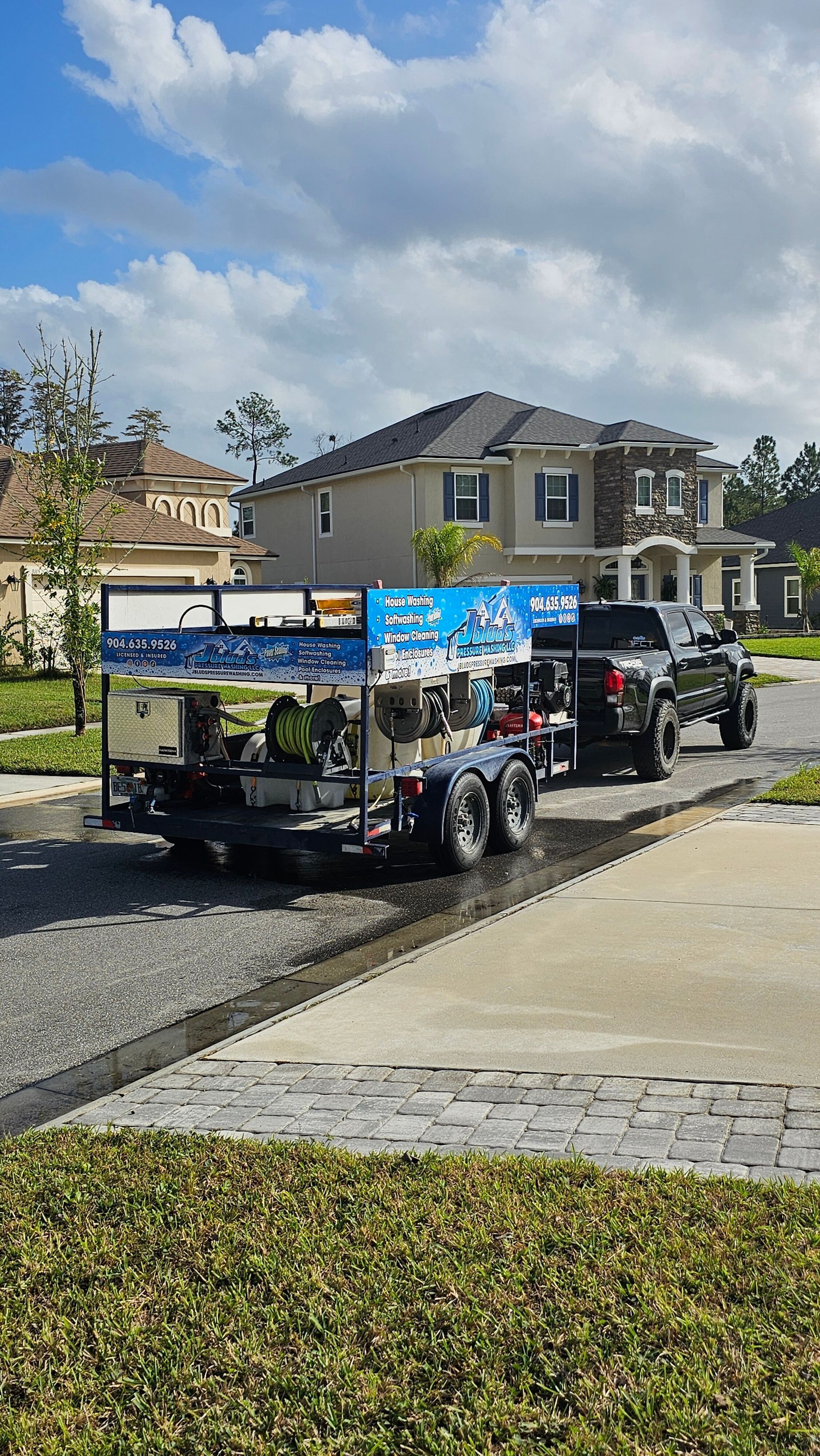 A bucket is sitting on a sidewalk next to a house.