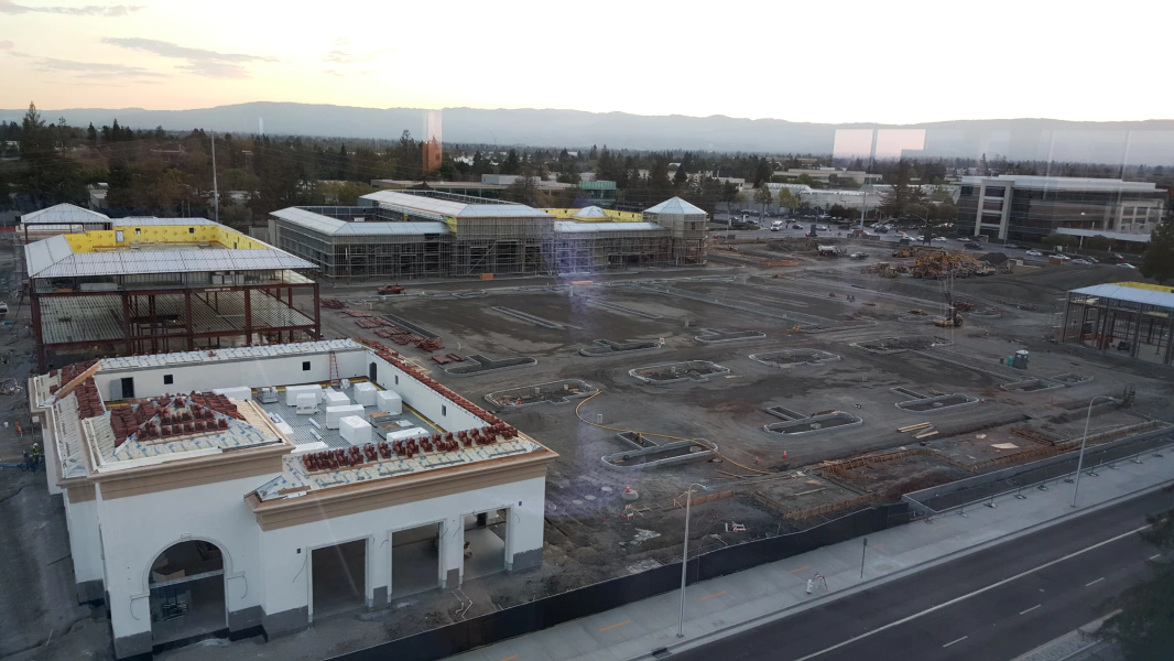 An aerial view of a building under construction in a city.
