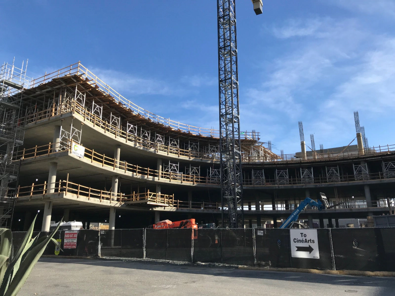 A large building under construction with a crane in the background.
