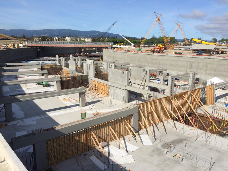 A large building under construction with a lot of concrete and wooden beams.