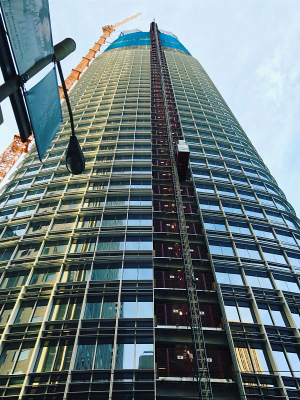 Looking up at a tall building with a crane in the background