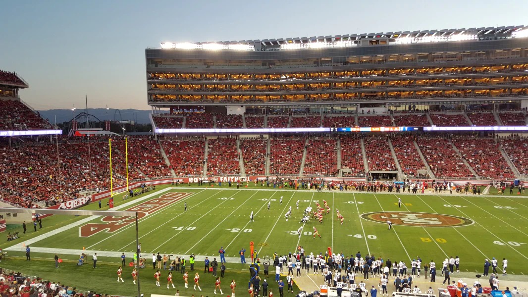 A football stadium filled with people watching a game.