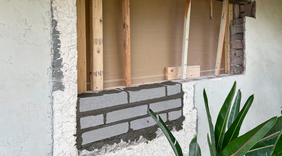 A brick wall is being built on the side of a building.