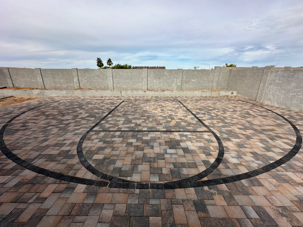 A basketball court made of bricks with a circle in the middle.