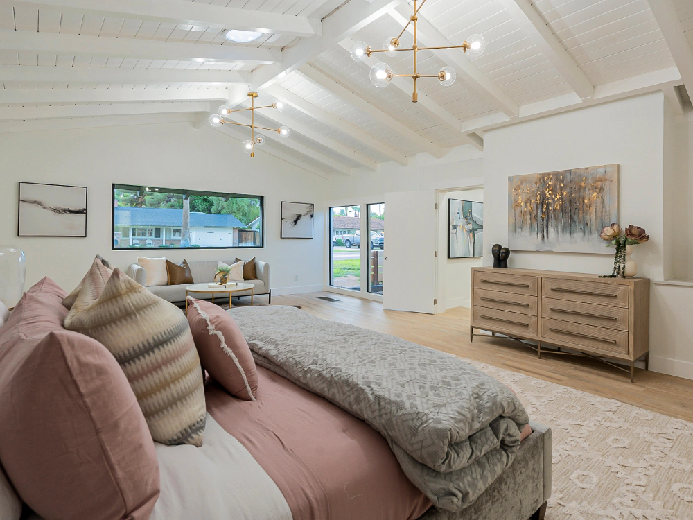 A bedroom with a large bed , dresser , and window.