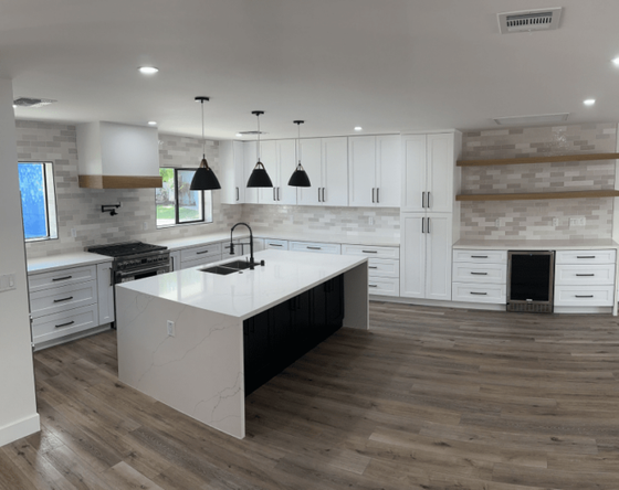 A kitchen with white cabinets and a large island