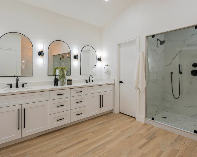 A bathroom with two sinks and a walk in shower.