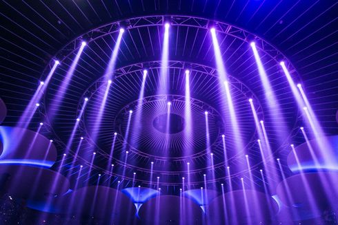 Lumières de scène violettes illuminant un plafond sombre en forme de dôme.