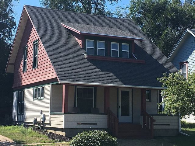 A house with a black roof and a porch
