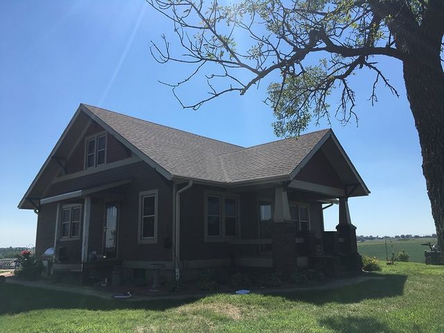 A house with a tree in front of it on a sunny day