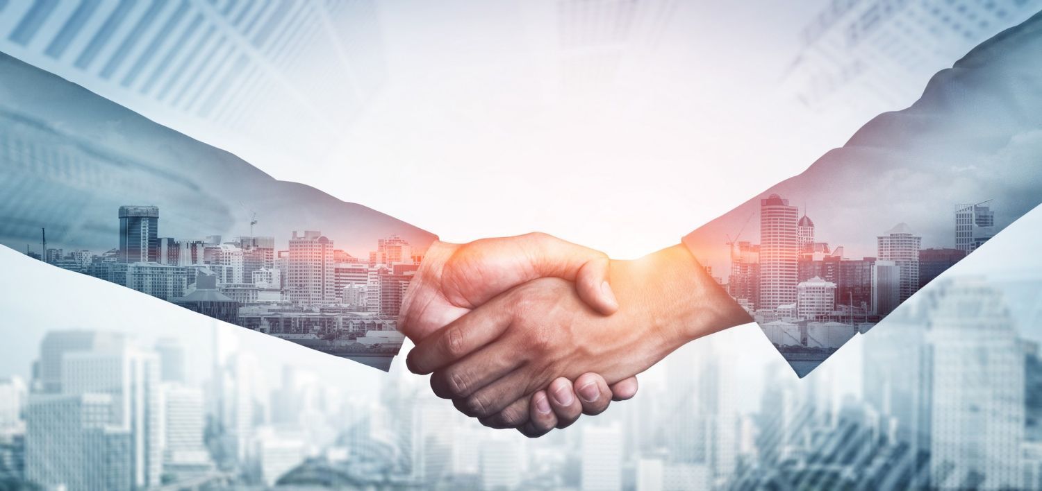 A close-up of a business handshake layered over a cityscape, symbolizing corporate partnership and professional success.