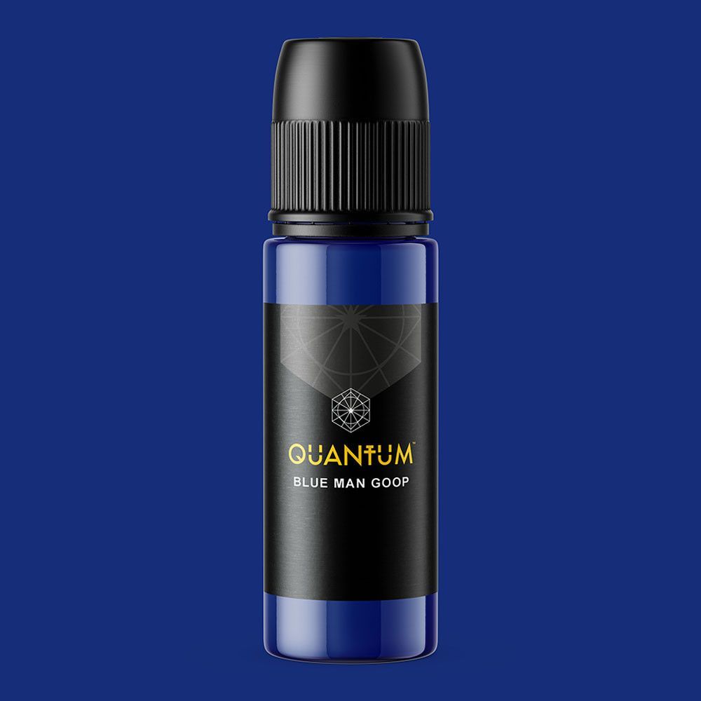 Blue bottle of Quantum Blue Man Goop. Black label with gold text and a geometric design.