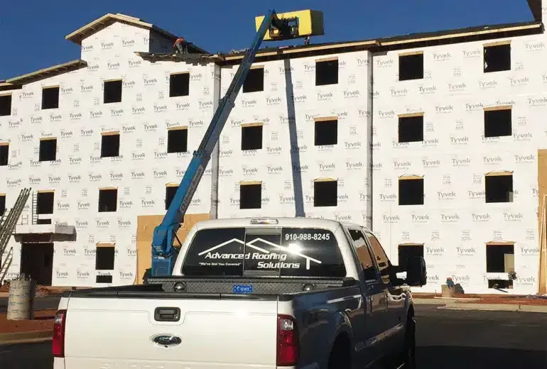 A truck is parked in front of a building under construction.