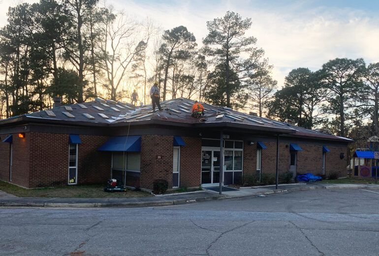 A man is standing on the roof of a brick building.