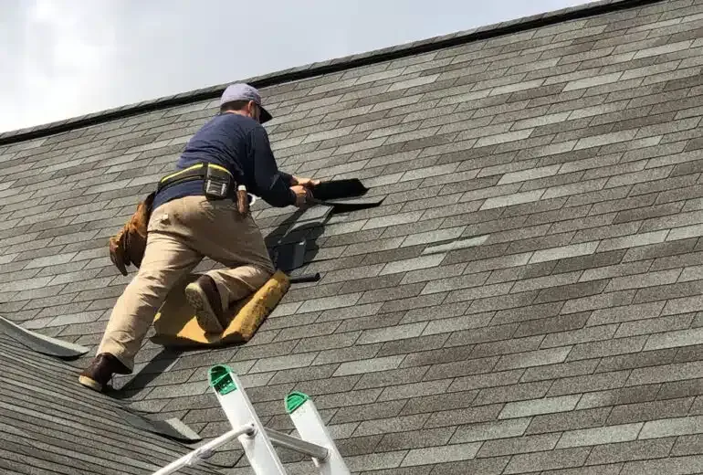 A man is working on the roof of a house.