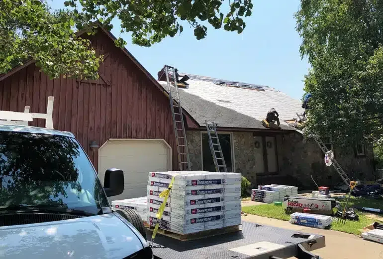 A van is parked in front of a house with a roof being installed.