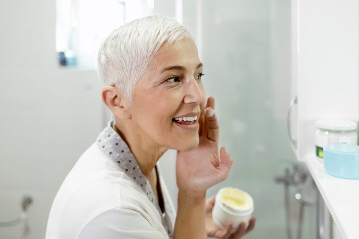 Senior woman applying cream to face | Canberra, ACT | Kingston Natural Therapies Centre
