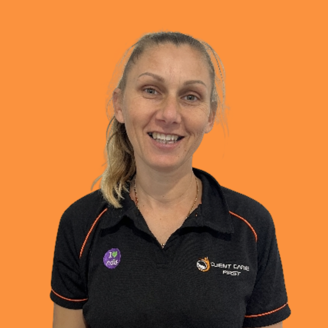 Woman with blonde hair smiling, wearing a black polo shirt with orange accents, against an orange background.