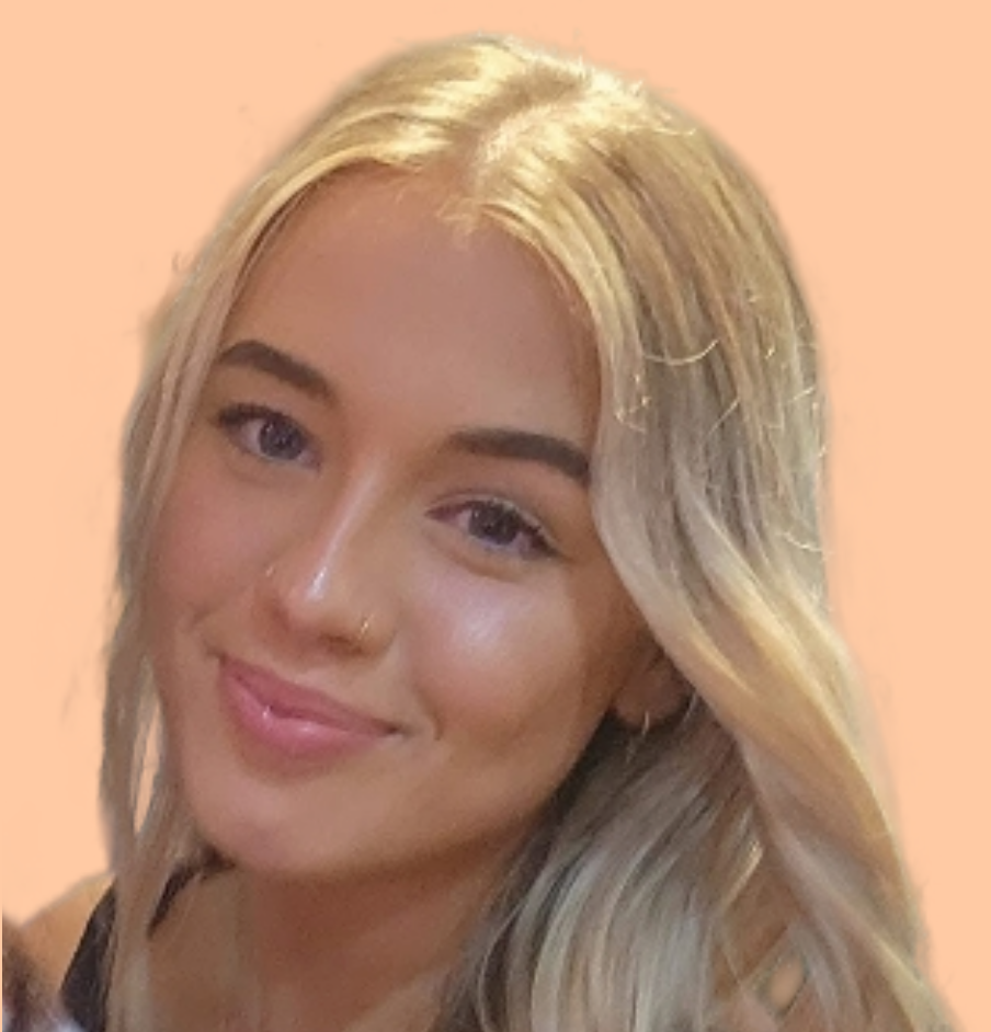 Blonde woman with blue eyes and a nose ring smiles. Light background.