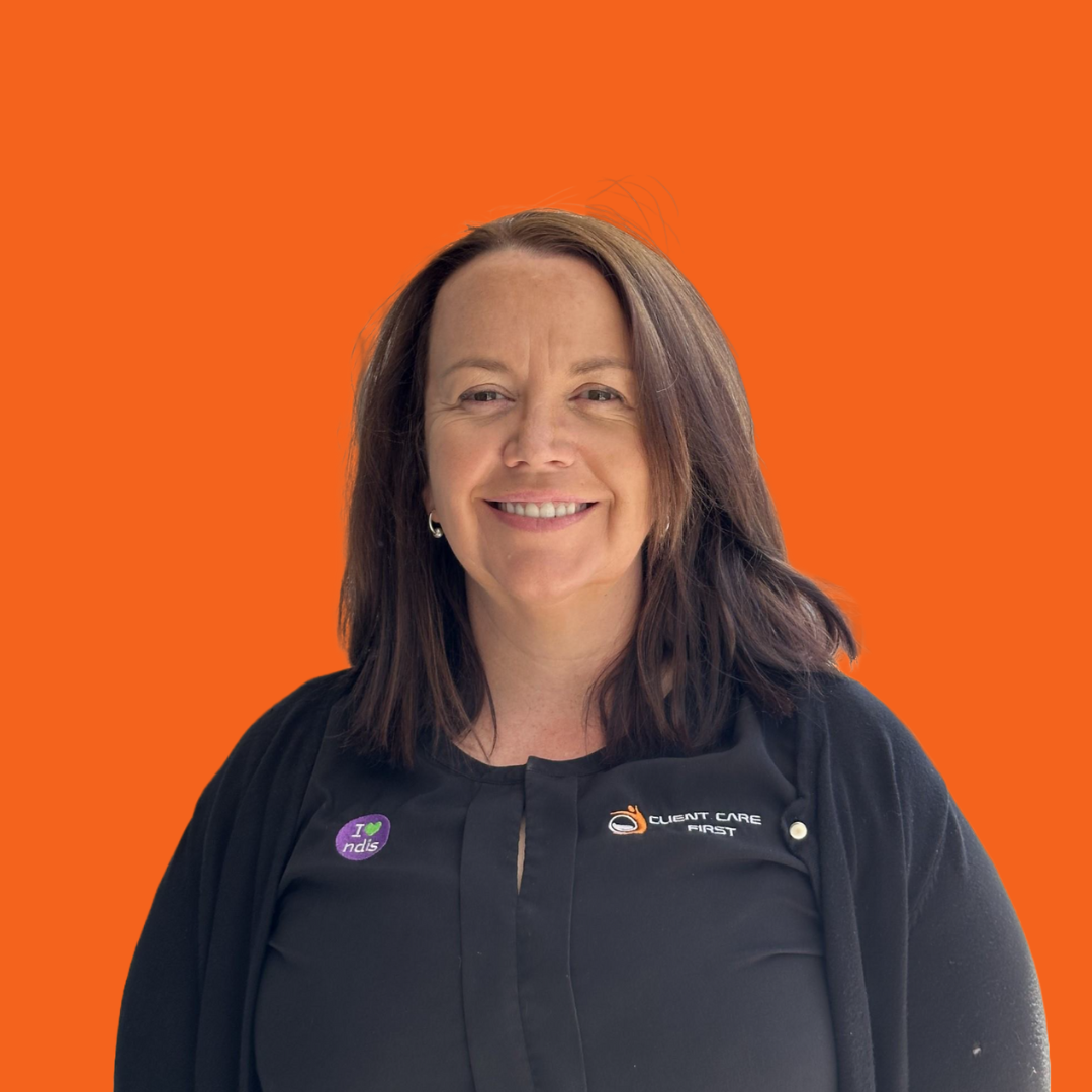 Woman with brown hair and a black shirt, smiling against an orange background.