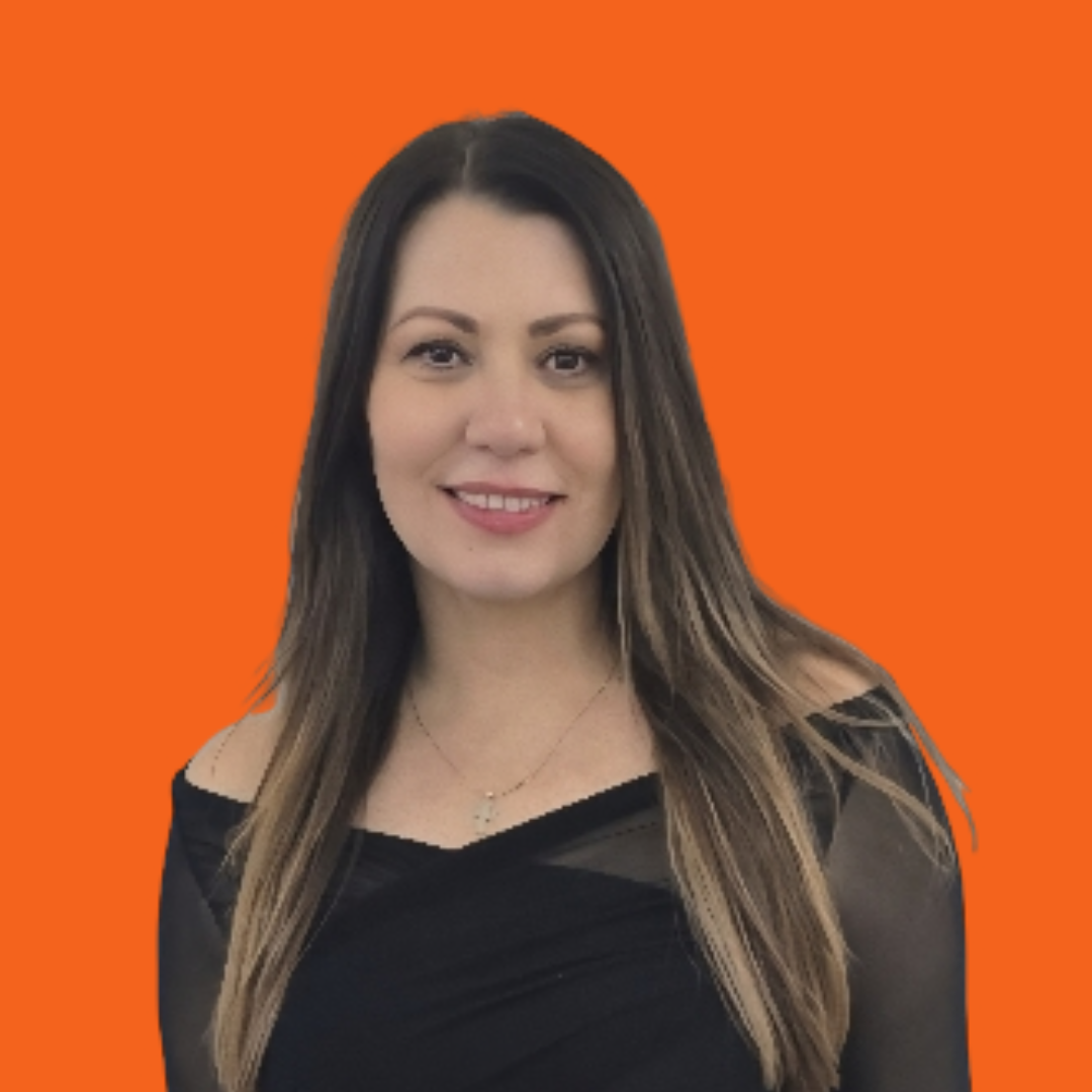 Woman with long brown hair, smiling, in a black off-shoulder top, against an orange backdrop.