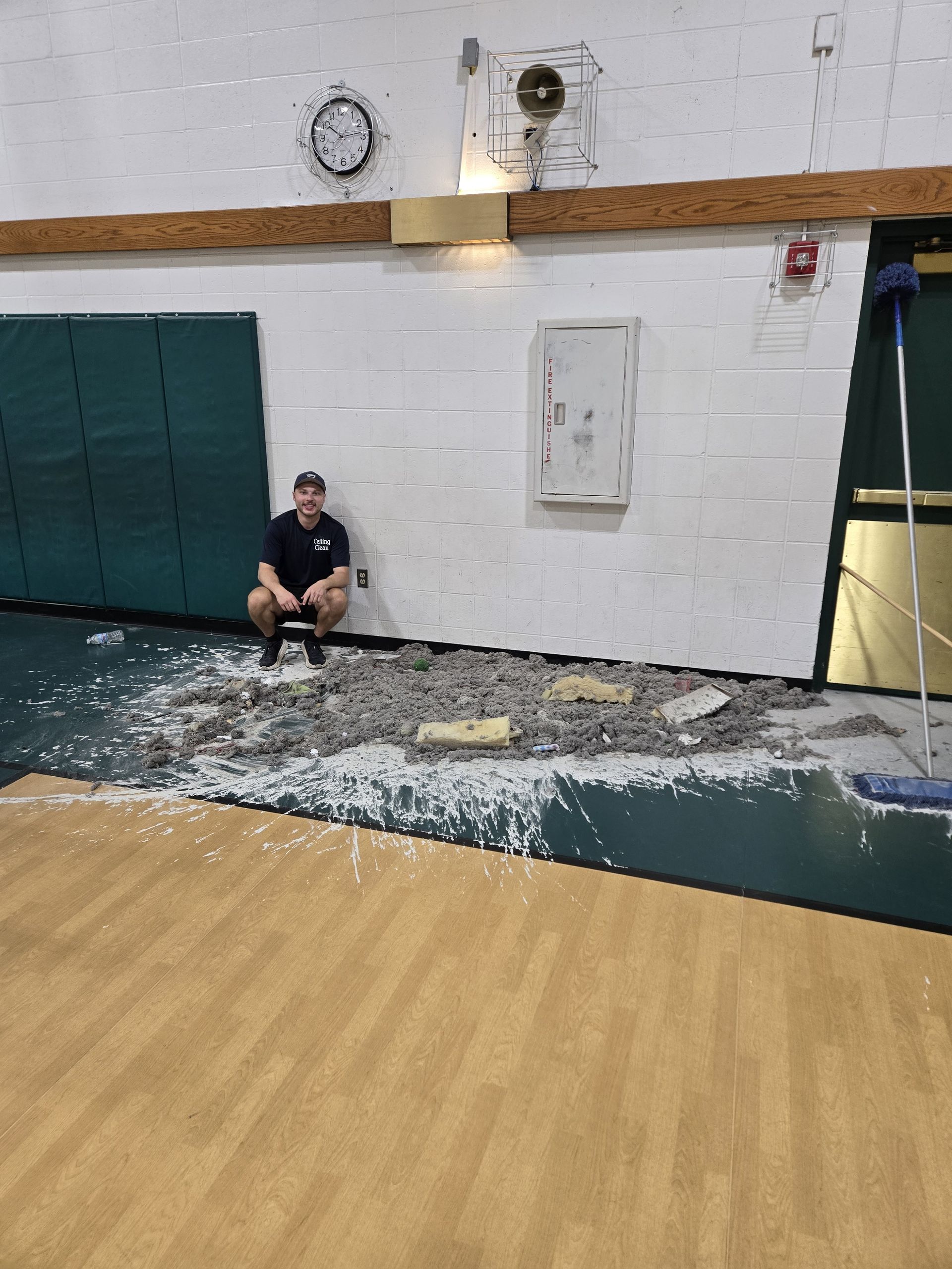 A man is sitting on the floor of a gym.