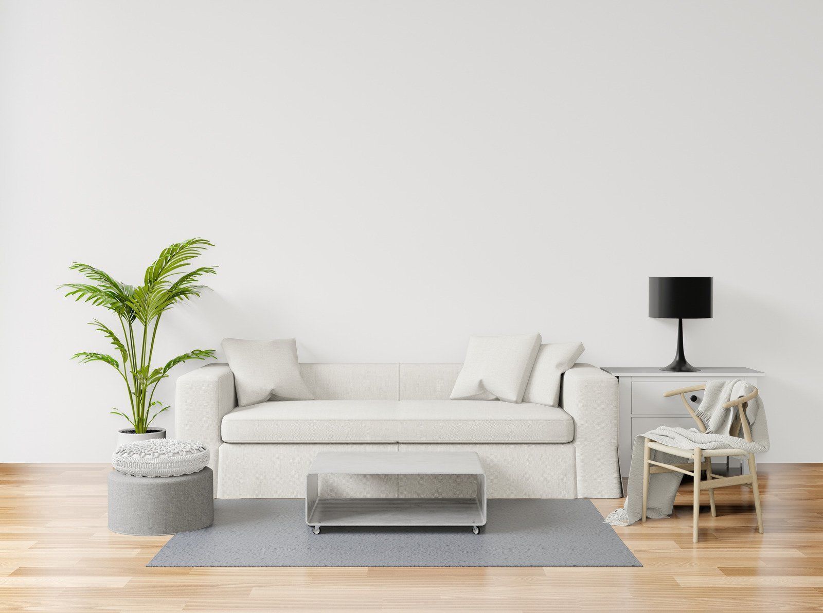 A living room with a white couch , table , chair and lamp.