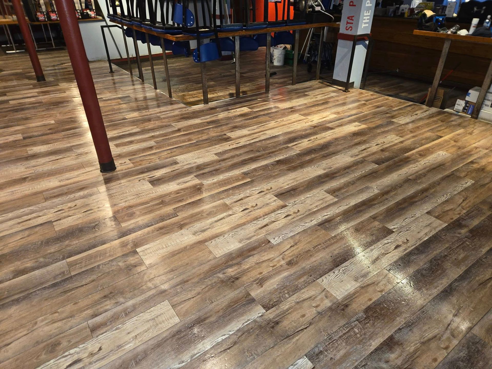 A wooden floor in a room with tables and chairs.