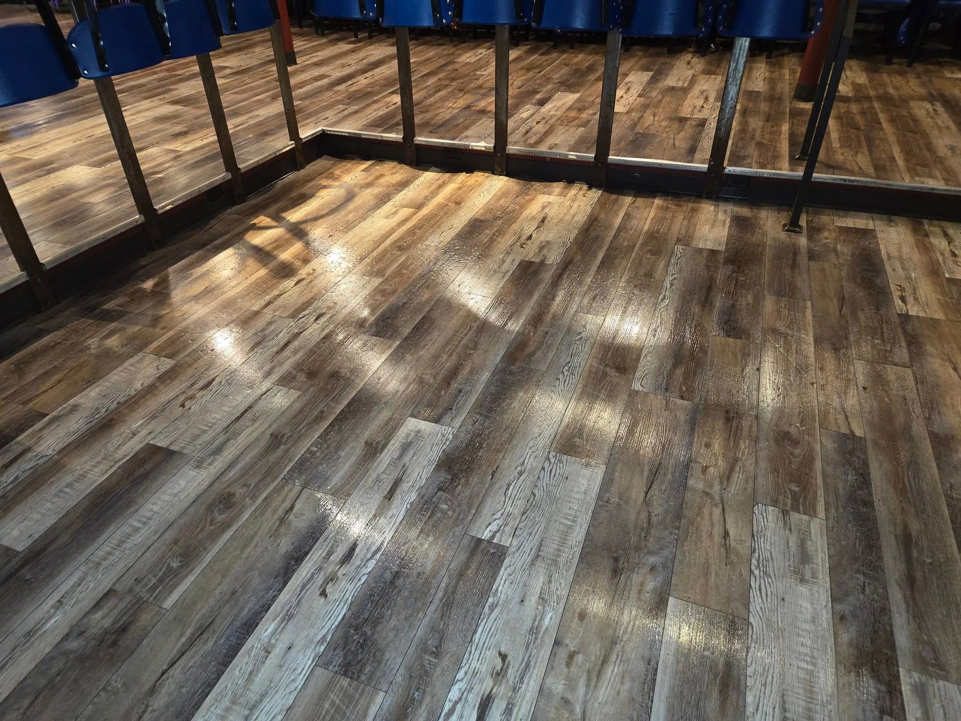 A wooden floor in a room with mirrors.