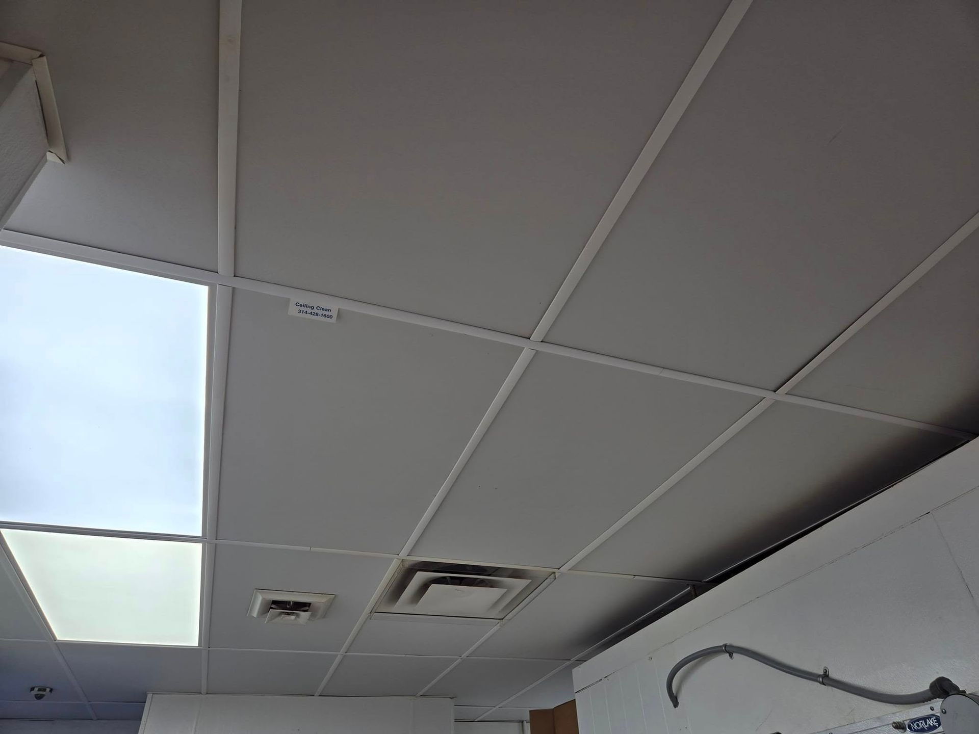 A white tiled ceiling with a light on it