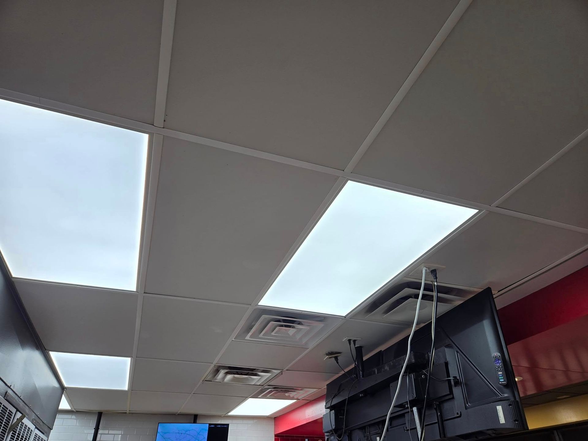 A ceiling with a lot of lights and a tv hanging from it.