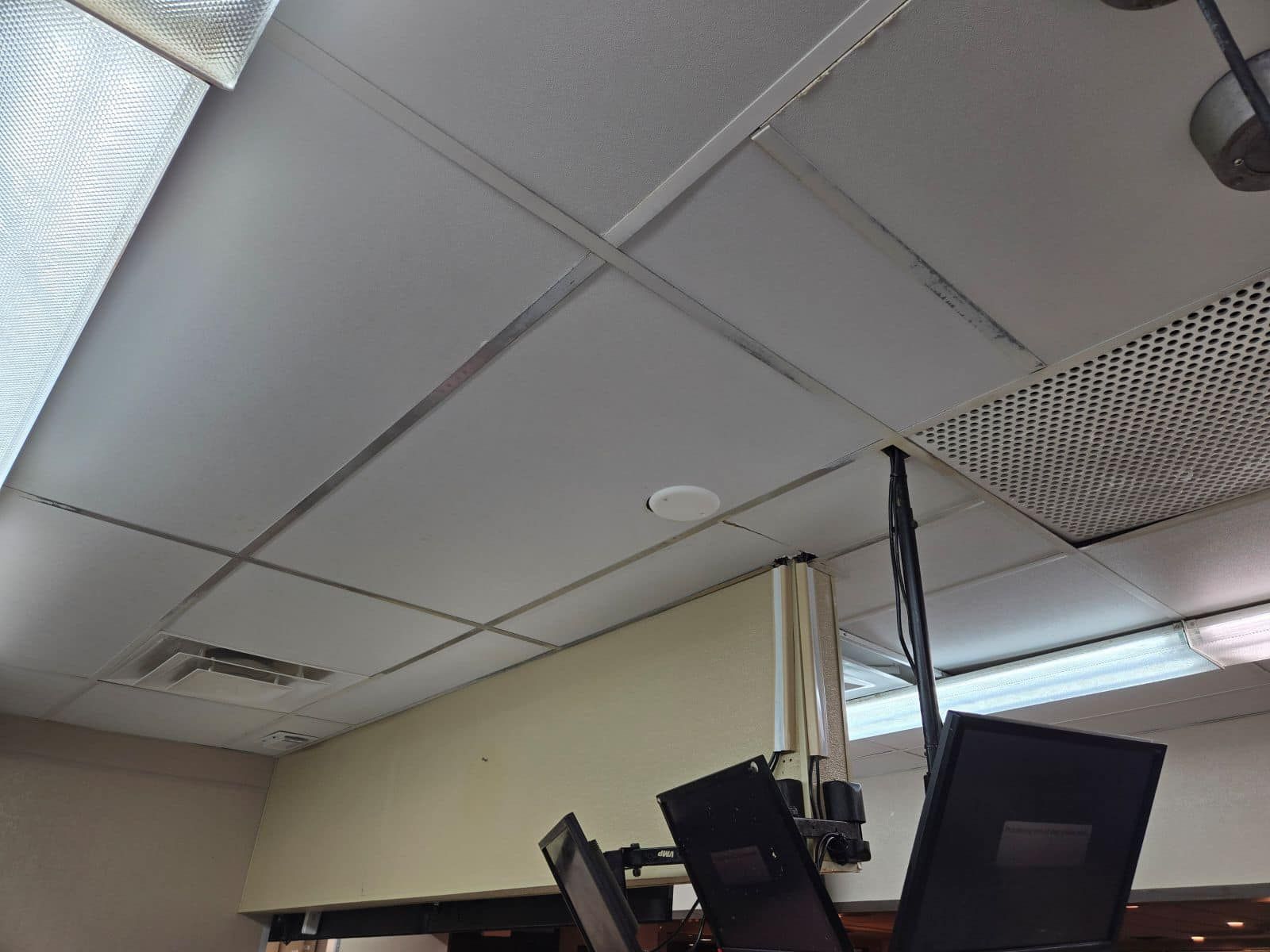A ceiling with two monitors hanging from it