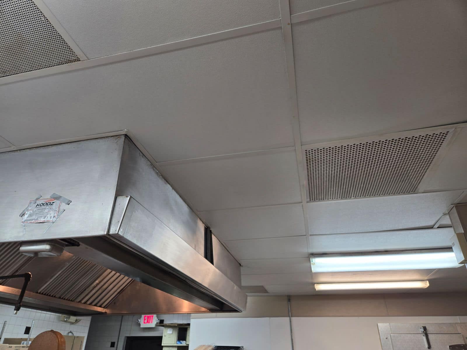 A kitchen with a stainless steel hood on the ceiling