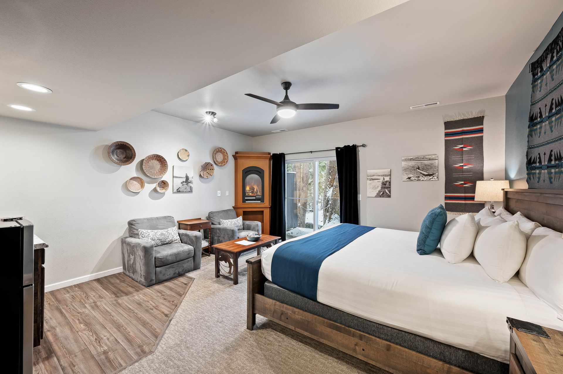 Bedroom with a bed, seating area, artwork, and sliding door to outdoors.