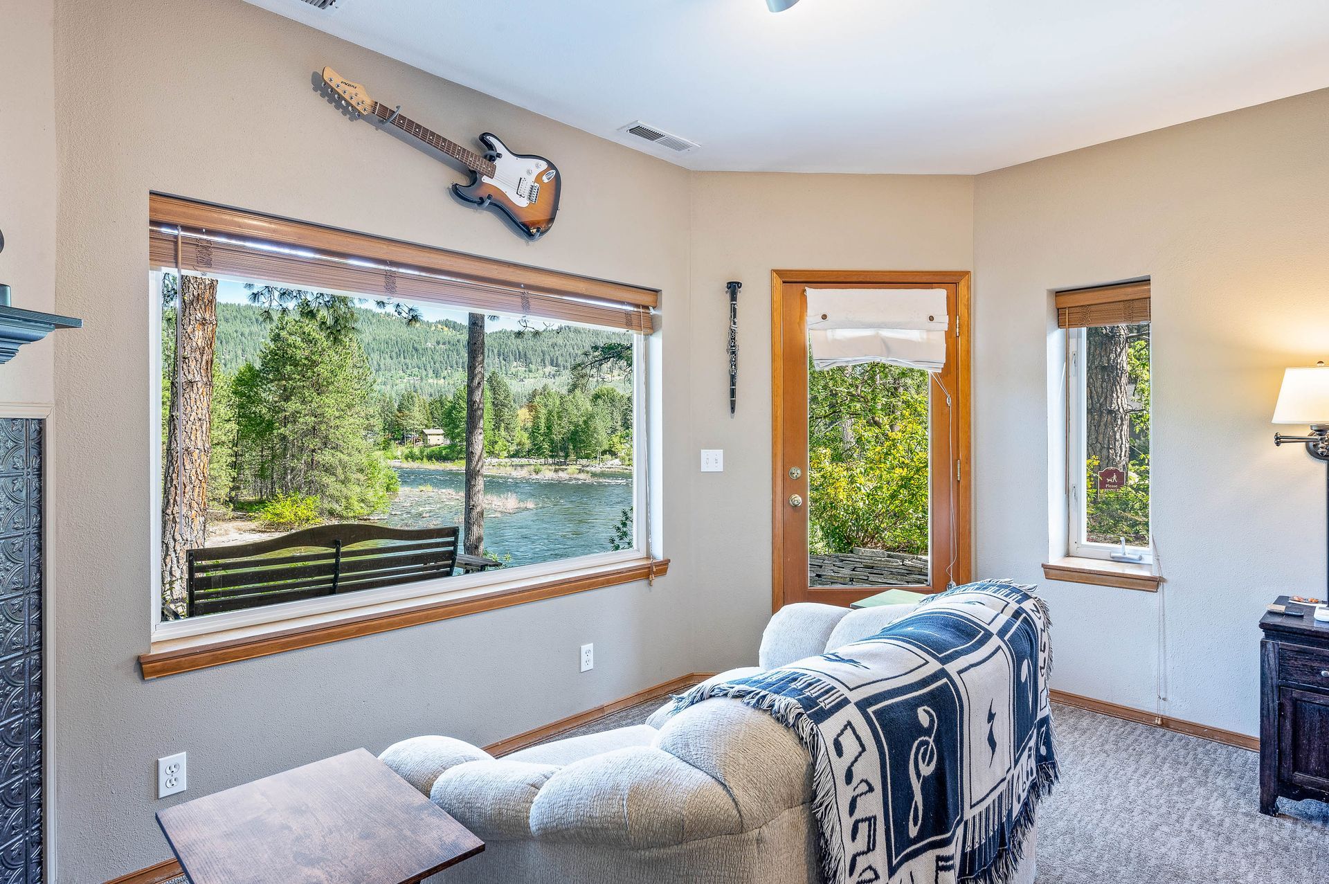 Living room with guitar decor, lake view, and door to outside.