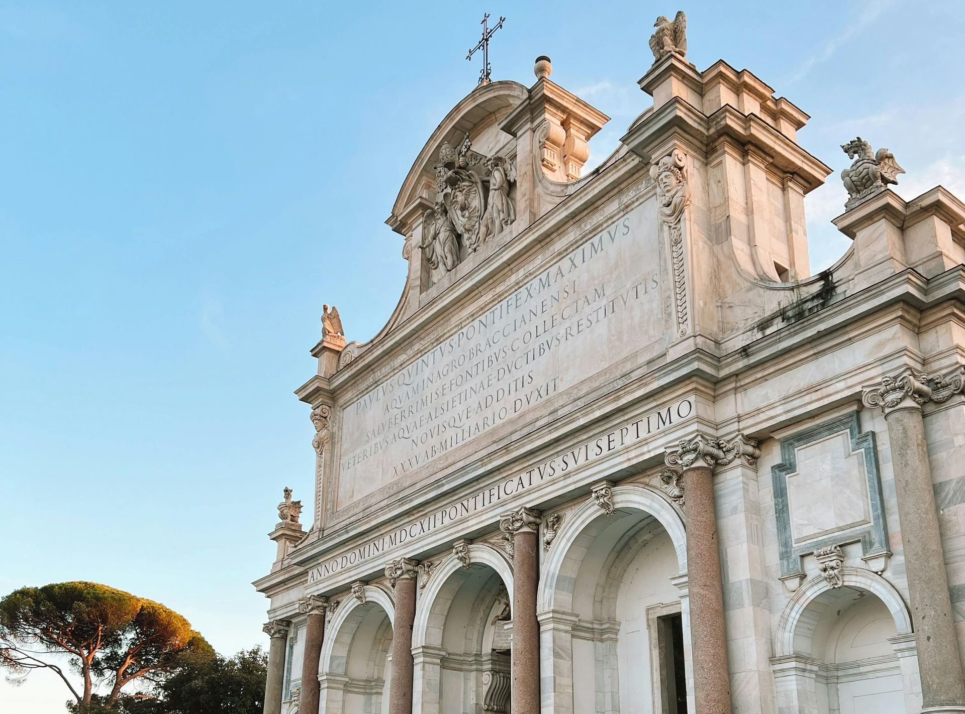 The grand facade of the Fontanone in Rome during sunset, with clear skies