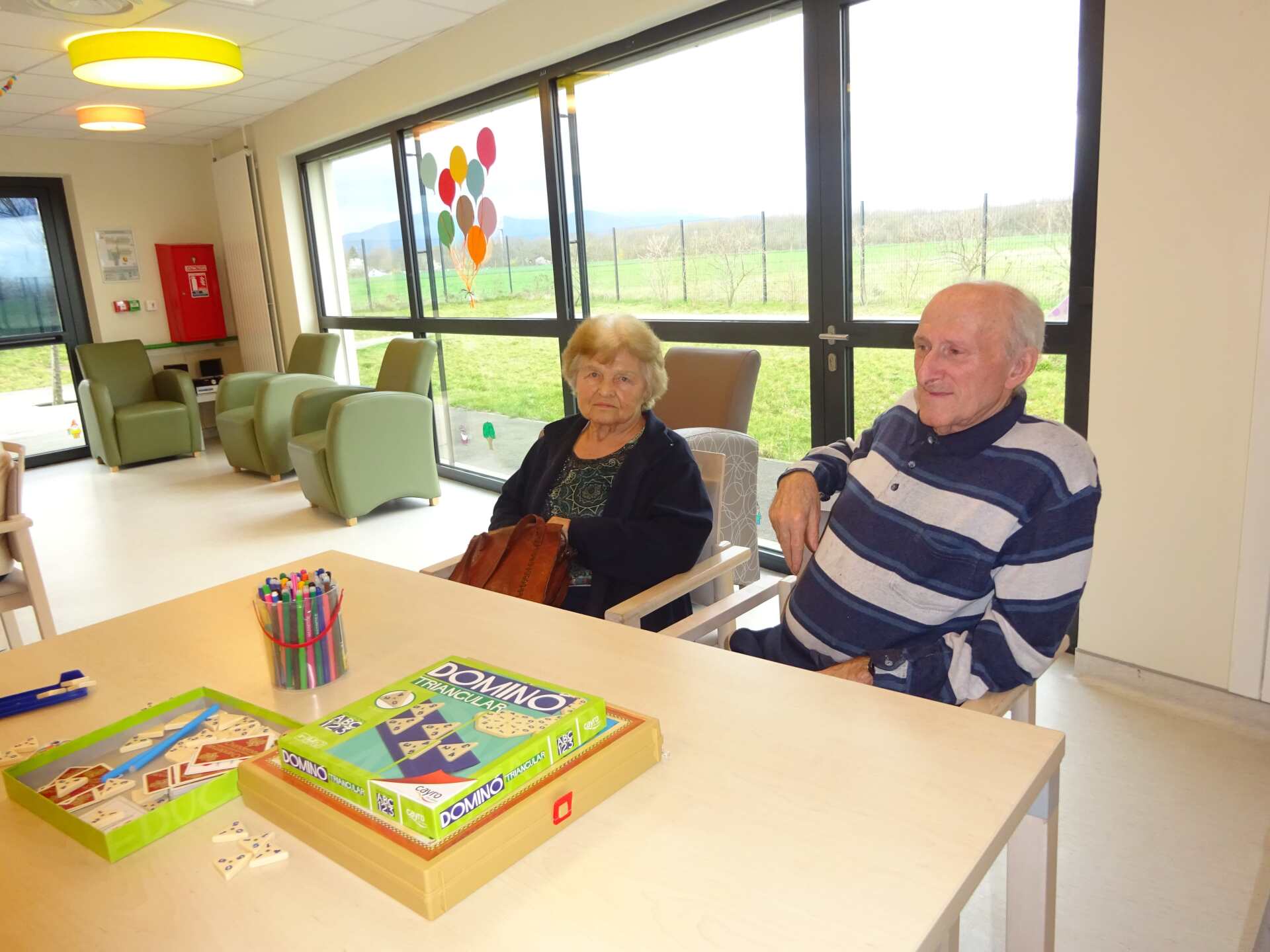 Un homme et une femme sont assis à une table avec des jeux dessus.