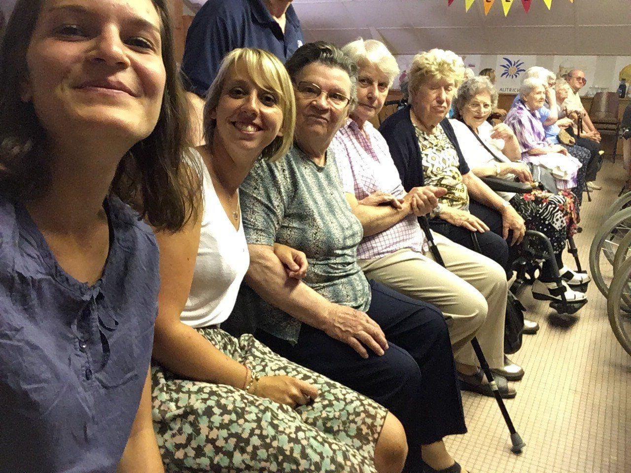 Un groupe de personnes sont assises en rang et se tiennent la main